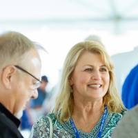 Guests standing under the tent at the Jamie Hosford Football Center dedication.